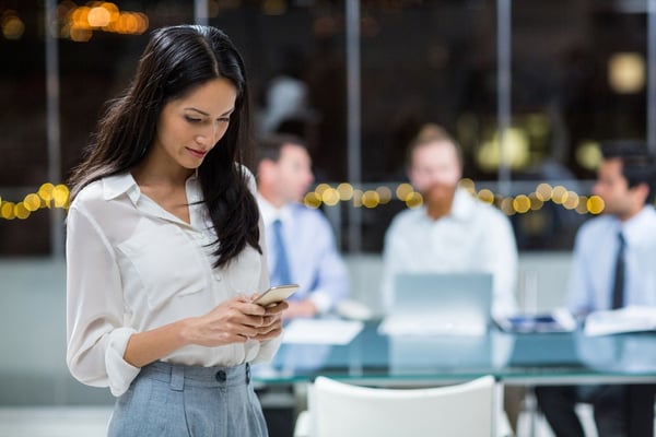 Businesswoman text messaging on mobile phone in the office